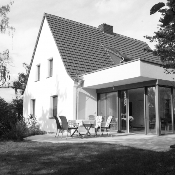 Eine Sitzgruppe vor einem Einfamilienhaus mit Anbau